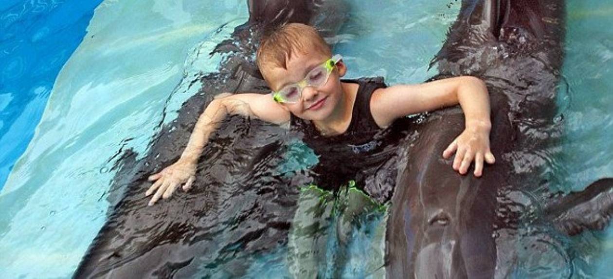 Παιδί με προσθετικά πόδια κολυμπάει με δελφίνι με προσθετική ουρά!