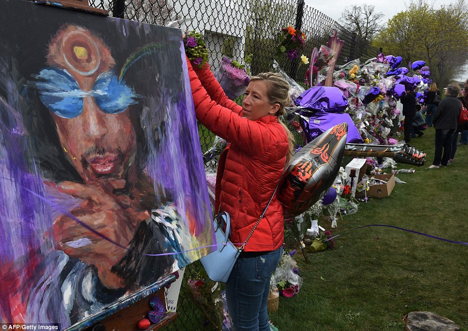 3372AE0700000578 3554472 A Prince fan attaches flowers to a memorial wall as she pays her a 11 1461362199355