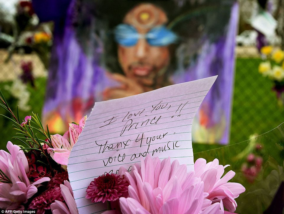 3372CCA000000578 3554472 A Prince fan holds flowers outside the Paisley Park compound in a 13 1461362199357