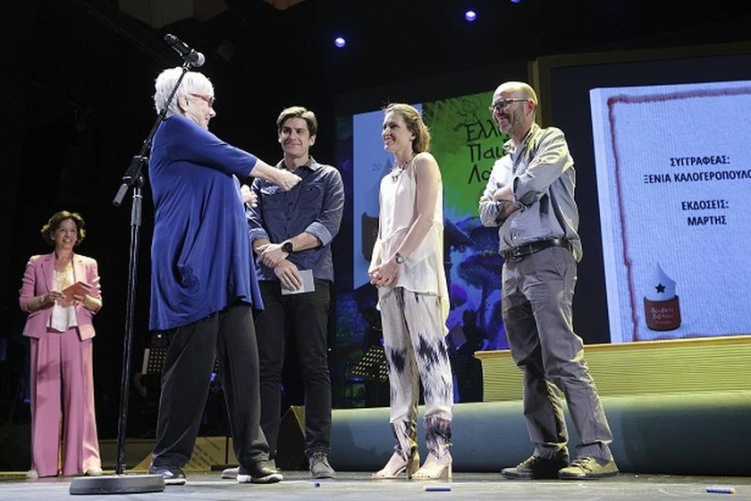 Η Ξένια Καλογεροπούλου παραλαμβάνει το Βραβείο της στη σκηνή του θεάτρου κι ευχαριστεί τους Άννα Παπαφίγκου, Γιάννη Γκανά και Φίλιππος Φωτιάδης των εκδόσεων Μάρτης. 