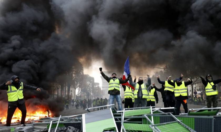 Χάος στο Παρίσι με τα «κίτρινα γιλέκα»: Άγριες συμπλοκές με οδοφράγματα, φωτιές τραυματίες και αύρες