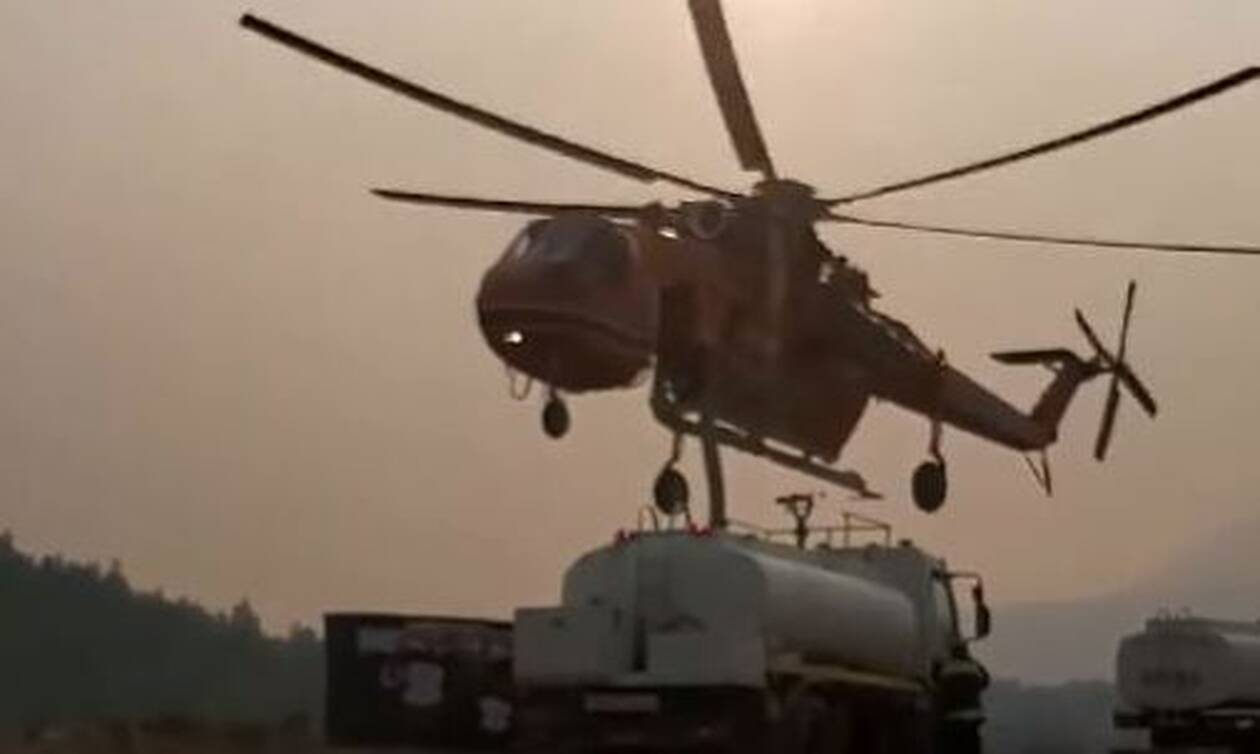 Στιγμιότυπο από τη μάχη με τις φλόγες στα Βίλια: Ελικόπτερο εφοδιάζεται από υδροφόρα
