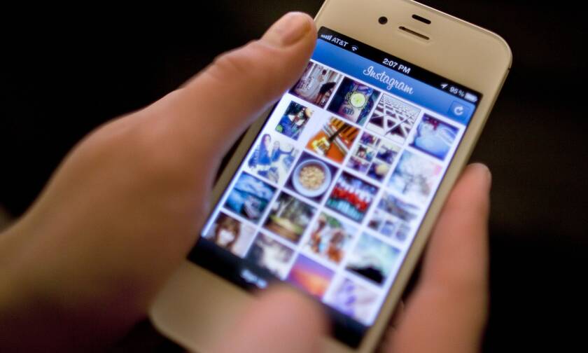 Χρήστης του Instagram ελέγχει το κινητό του τηλέφωνο
