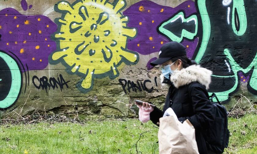 Γυναίκα στη Βρετανία μπροστά απο το σύμβολο του κορονοϊού