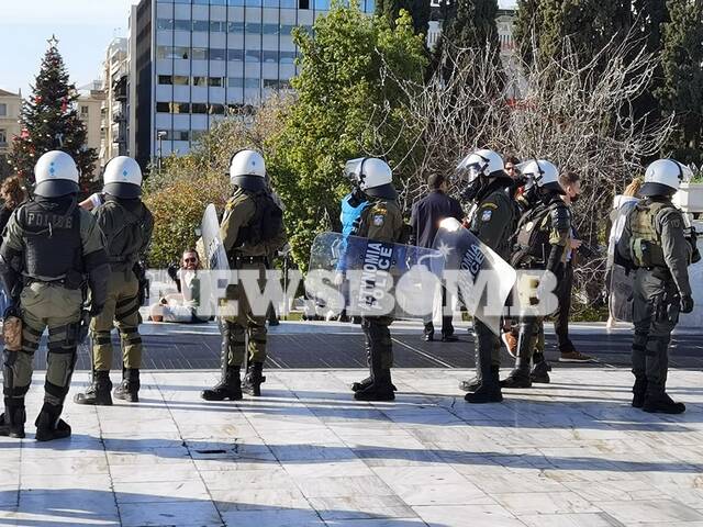 Αστυνομικοί παρακολουθούν την πορεία από απόσταση στο κέντρο της Αθήνας