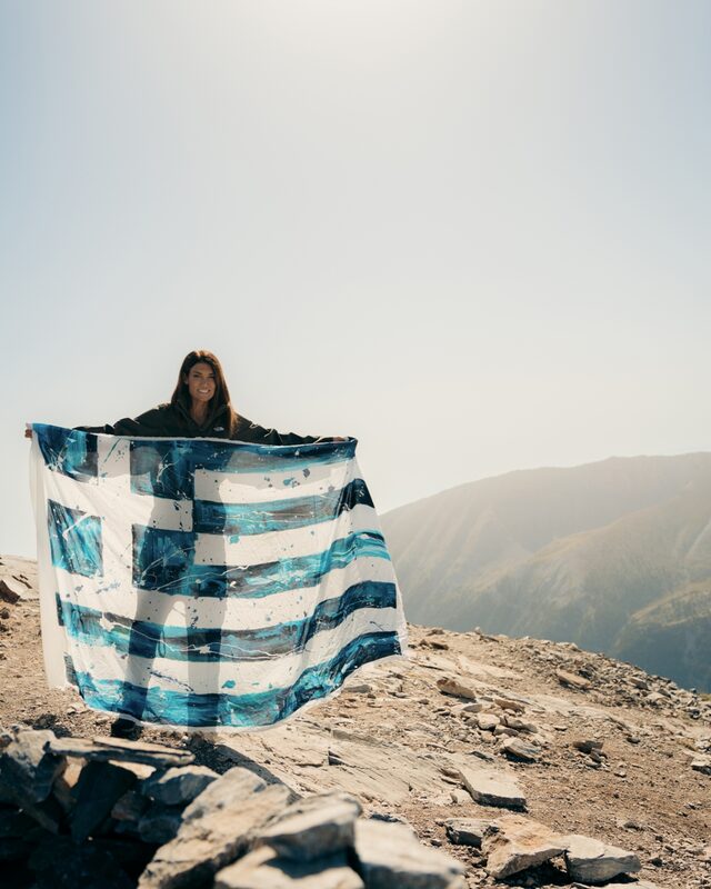 Η εικαστικός Καρολίνα Ροβύθη ζωγραφίζει την ελληνική σημαία στον Όλυμπο