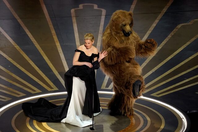 Η Ελίζαμπεθ Μπανκς και ένας ηθοποιός ντυμένος αρκούδα σε μια αναφορά στο Cocaine Bear όπου πρωταγωνιστούσε η ηθοποιός 